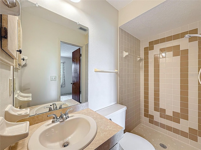 10139 Carrin Rd, Spring Hill, FL 34608 - full bath featuring tiled shower, a textured ceiling, toilet, and vanity