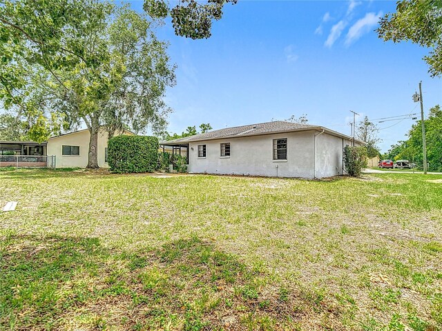 10139 Carrin Rd, Spring Hill, FL 34608 - rear view of property featuring stucco siding and a yard