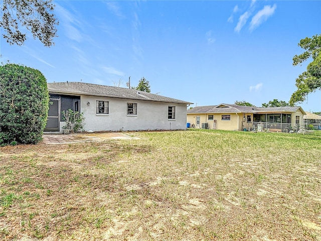 10139 Carrin Rd, Spring Hill, FL 34608 - back of property featuring stucco siding, a lawn, and cooling unit