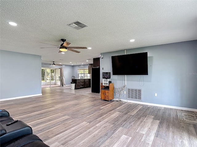 11340 Corinthian St, Spring Hill, FL 34609 - unfurnished living room featuring a ceiling fan, light wood-style flooring, baseboards, a textured ceiling, and recessed lighting