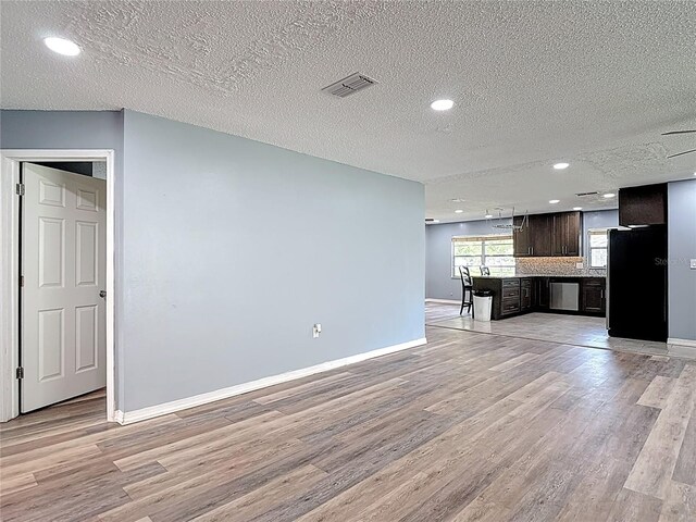 11340 Corinthian St, Spring Hill, FL 34609 - unfurnished living room with light wood-style floors, baseboards, a textured ceiling, and recessed lighting