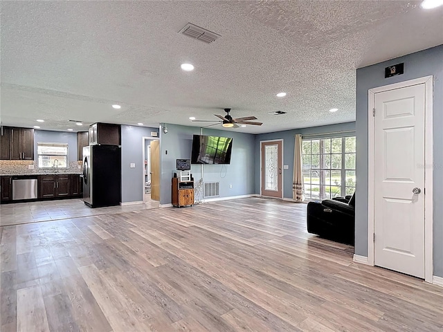 11340 Corinthian St, Spring Hill, FL 34609 - unfurnished living room with baseboards, light wood finished floors, a textured ceiling, ceiling fan, and recessed lighting