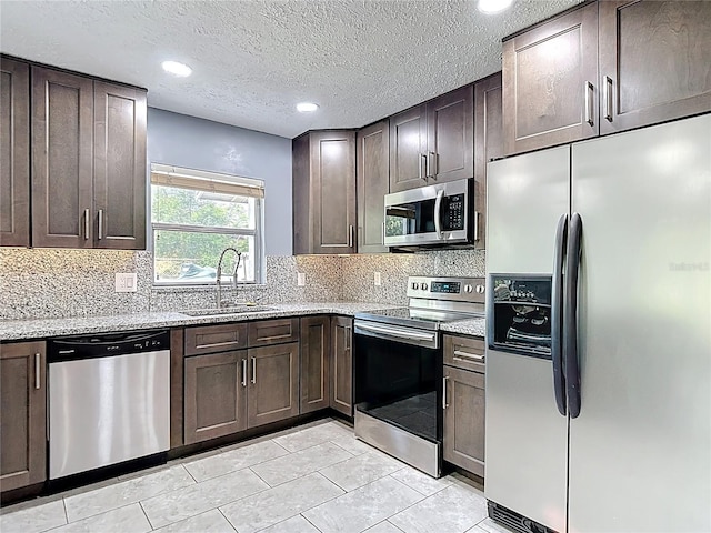 11340 Corinthian St, Spring Hill, FL 34609 - kitchen featuring stainless steel appliances, a sink, dark brown cabinetry, light stone counters, and recessed lighting