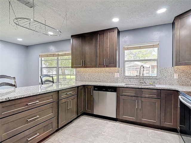 11340 Corinthian St, Spring Hill, FL 34609 - kitchen featuring appliances with stainless steel finishes, a textured ceiling, a sink, light stone counters, and tasteful backsplash