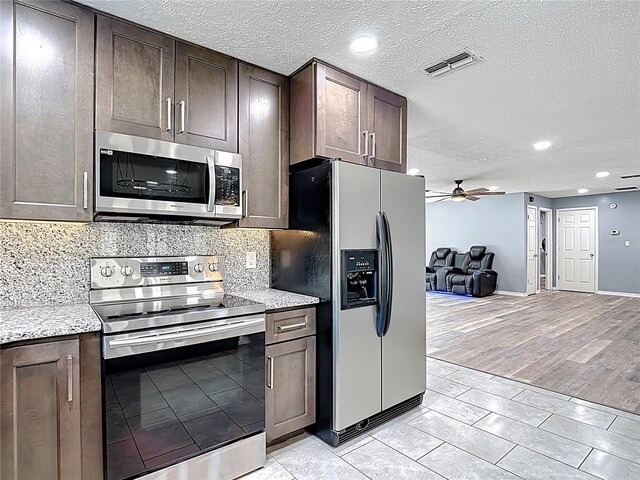 11340 Corinthian St, Spring Hill, FL 34609 - kitchen featuring stainless steel appliances, open floor plan, dark brown cabinets, a ceiling fan, and a textured ceiling