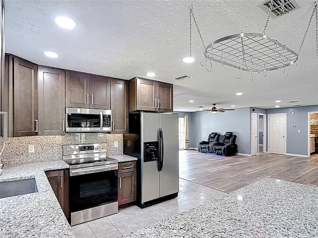 11340 Corinthian St, Spring Hill, FL 34609 - kitchen with stainless steel appliances, dark brown cabinetry, open floor plan, ceiling fan, and recessed lighting