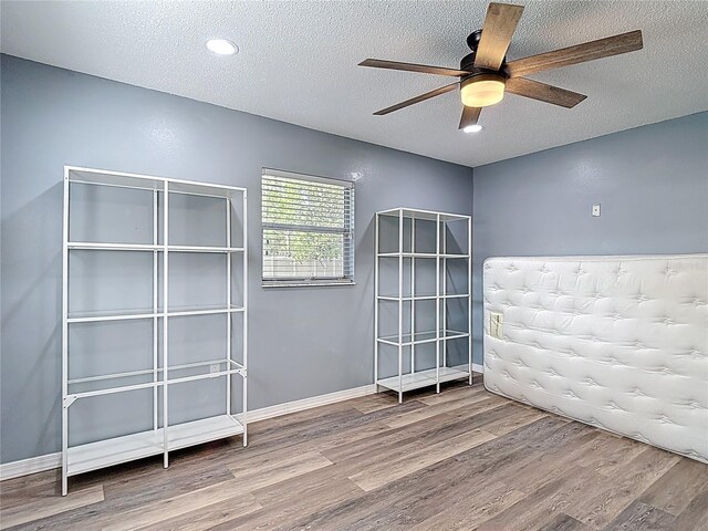 11340 Corinthian St, Spring Hill, FL 34609 - spare room featuring wood finished floors, a textured ceiling, ceiling fan, and baseboards