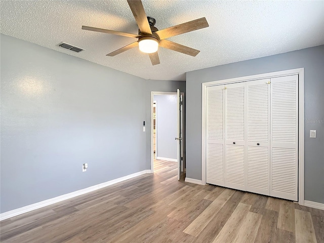 11340 Corinthian St, Spring Hill, FL 34609 - unfurnished bedroom featuring wood finished floors, a textured ceiling, baseboards, a closet, and ceiling fan