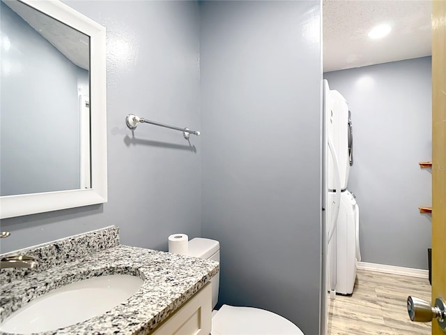 11340 Corinthian St, Spring Hill, FL 34609 - full bath with stacked washing machine and dryer, vanity, toilet, wood finished floors, and recessed lighting