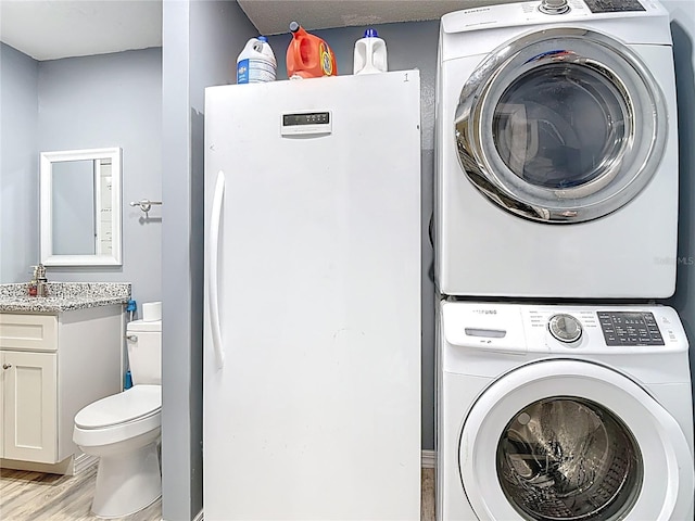 11340 Corinthian St, Spring Hill, FL 34609 - laundry area featuring stacked washer / drying machine and light wood-type flooring