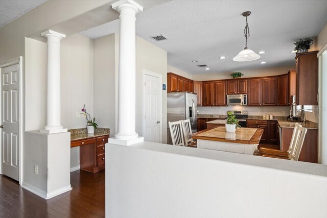 17905 Machair Ln, Land O Lakes, FL 34638 - kitchen with stainless steel appliances, decorative columns, a center island, dark wood-style flooring, and recessed lighting