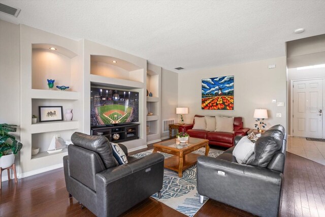 17905 Machair Ln, Land O Lakes, FL 34638 - living area with built in features, a textured ceiling, wood finished floors, and baseboards