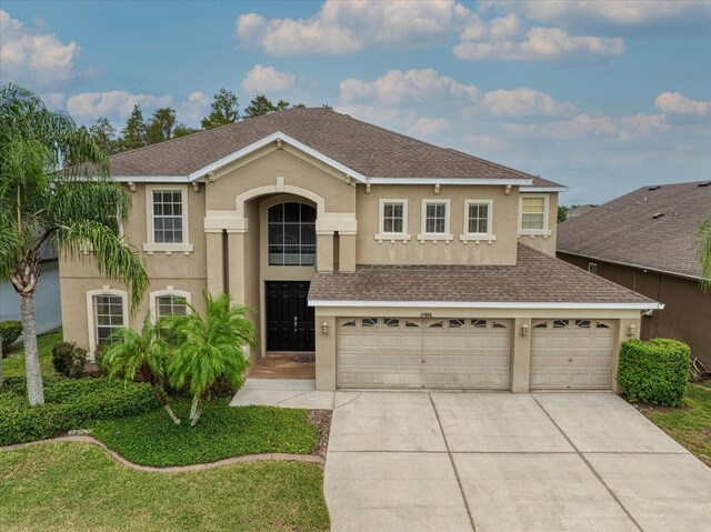 17905 Machair Ln, Land O Lakes, FL 34638 - traditional home featuring roof with shingles, stucco siding, driveway, and a garage