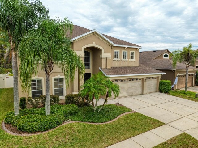 17905 Machair Ln, Land O Lakes, FL 34638 - mediterranean / spanish-style home with concrete driveway, stucco siding, and roof with shingles