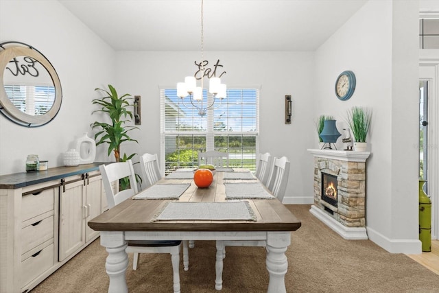 11042 Heth Ct, Weeki Wachee, FL 34613 - dining room featuring a chandelier, light colored carpet, baseboards, and a fireplace