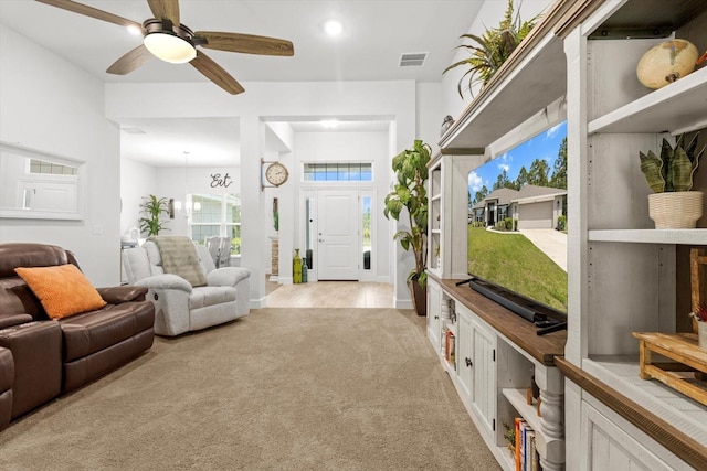 11042 Heth Ct, Weeki Wachee, FL 34613 - living room featuring light colored carpet and ceiling fan