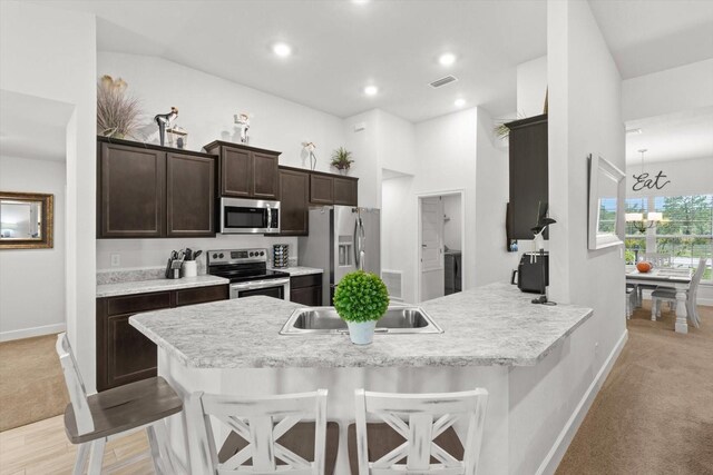 11042 Heth Ct, Weeki Wachee, FL 34613 - kitchen with appliances with stainless steel finishes, dark brown cabinets, baseboards, light colored carpet, and light countertops