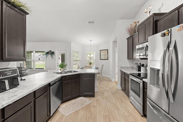 11042 Heth Ct, Weeki Wachee, FL 34613 - kitchen featuring stainless steel appliances, a sink, dark brown cabinetry, light countertops, and light wood-style flooring