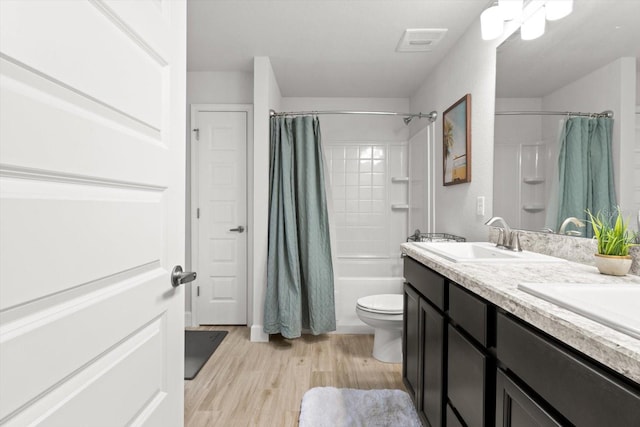 11042 Heth Ct, Weeki Wachee, FL 34613 - full bath featuring toilet, shower / bathtub combination with curtain, wood finished floors, and double vanity