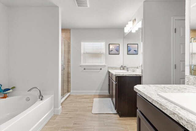 11042 Heth Ct, Weeki Wachee, FL 34613 - full bath with two vanities, a shower stall, a garden tub, and baseboards
