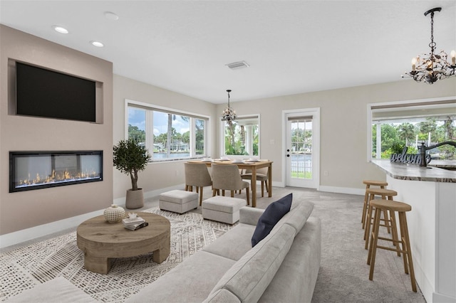 5440 Manatee Point Dr, New Port Richey, FL 34652 - living area featuring a chandelier, baseboards, plenty of natural light, recessed lighting, and light carpet