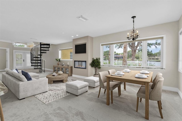 5440 Manatee Point Dr, New Port Richey, FL 34652 - carpeted dining space with a chandelier, a fireplace, baseboards, stairs, and recessed lighting