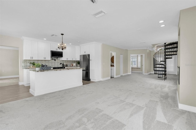 5440 Manatee Point Dr, New Port Richey, FL 34652 - kitchen featuring freestanding refrigerator, light carpet, open floor plan, baseboards, and backsplash