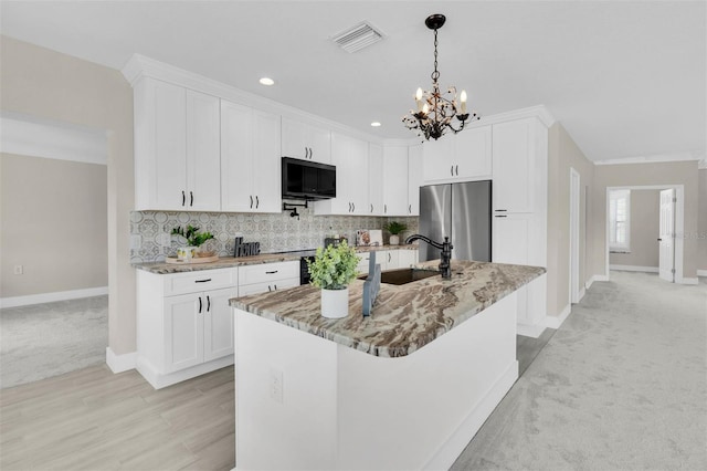 5440 Manatee Point Dr, New Port Richey, FL 34652 - kitchen featuring stainless steel fridge, baseboards, a chandelier, light stone counters, and backsplash