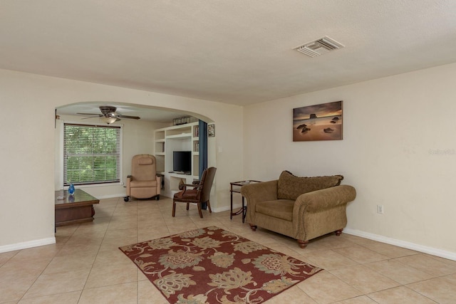 3140 Bahia Ave, Holiday, FL 34690 - living room with a ceiling fan, arched walkways, light tile patterned flooring, and baseboards