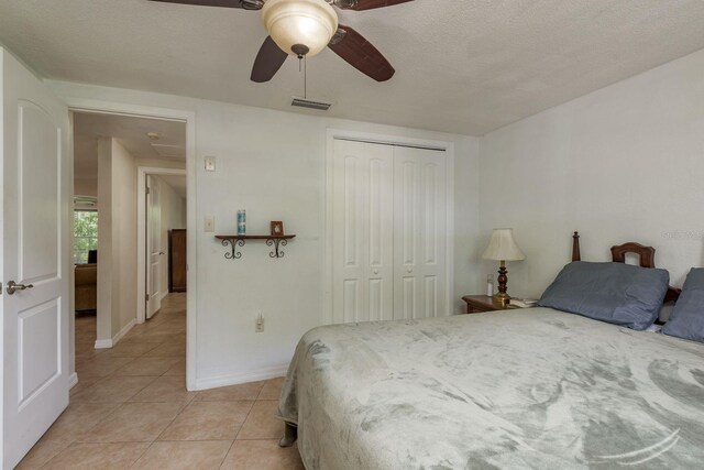 3140 Bahia Ave, Holiday, FL 34690 - bedroom with light tile patterned flooring, a closet, ceiling fan, a textured ceiling, and baseboards