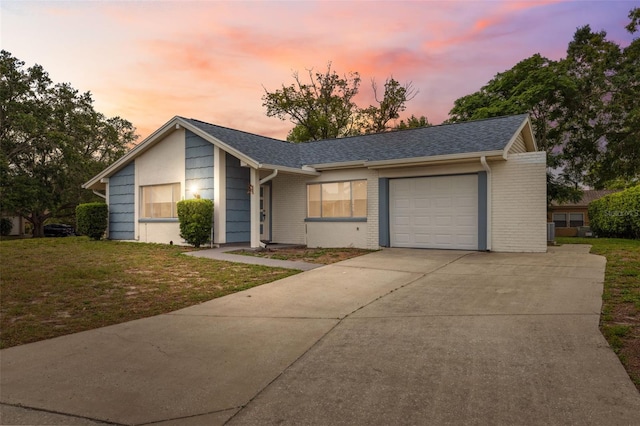 13001 Sawmill Way, Hudson, FL 34667 - view of front facade featuring an attached garage, concrete driveway, brick siding, and a yard