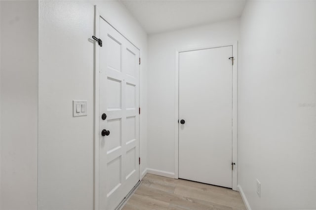 13001 Sawmill Way, Hudson, FL 34667 - doorway to outside featuring light wood-type flooring and baseboards