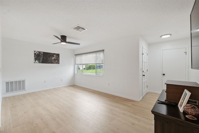 13001 Sawmill Way, Hudson, FL 34667 - empty room featuring a textured ceiling, a ceiling fan, baseboards, and light wood-style floors