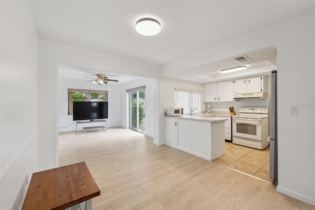 13001 Sawmill Way, Hudson, FL 34667 - kitchen featuring white appliances, range hood, light wood finished floors, open floor plan, and light countertops