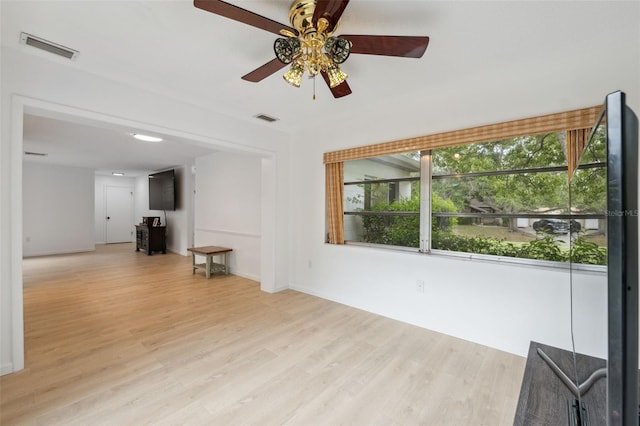 13001 Sawmill Way, Hudson, FL 34667 - unfurnished living room featuring healthy amount of natural light, light wood finished floors, and ceiling fan