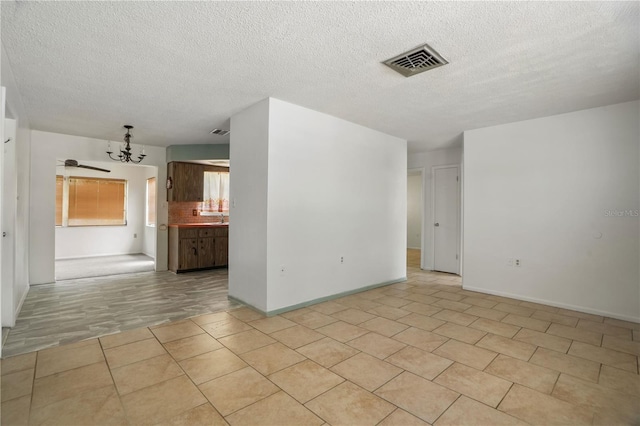 8053 Dedham Dr, Port Richey, FL 34668 - unfurnished room with a textured ceiling, a chandelier, and baseboards