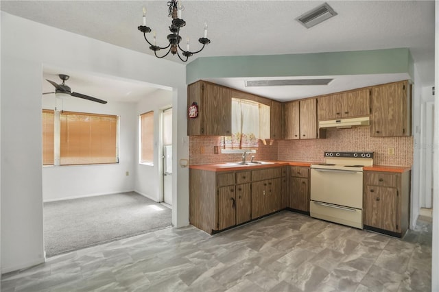 8053 Dedham Dr, Port Richey, FL 34668 - kitchen featuring white range with electric stovetop, under cabinet range hood, plenty of natural light, a sink, and a textured ceiling