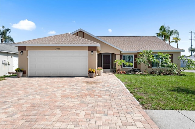 7923 Woburn St, New Port Richey, FL 34653 - ranch-style home featuring decorative driveway, stucco siding, a front lawn, an attached garage, and roof with shingles