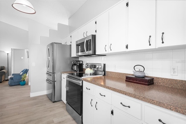 7923 Woburn St, New Port Richey, FL 34653 - kitchen featuring stainless steel appliances, white cabinets, backsplash, and dark countertops