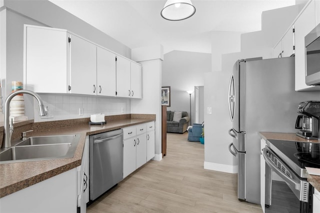 7923 Woburn St, New Port Richey, FL 34653 - kitchen with stainless steel appliances, a sink, white cabinets, and lofted ceiling