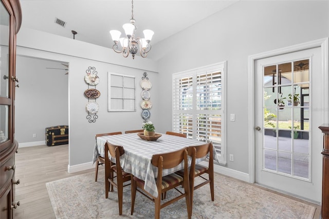 7923 Woburn St, New Port Richey, FL 34653 - dining room with a chandelier, light wood-style flooring, and baseboards