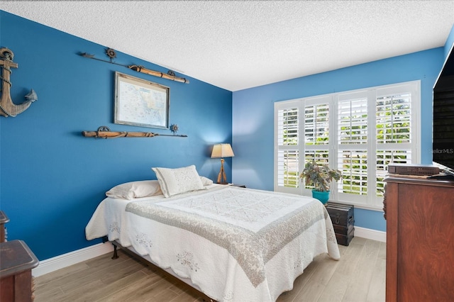 7923 Woburn St, New Port Richey, FL 34653 - bedroom featuring wood finished floors, a textured ceiling, and baseboards