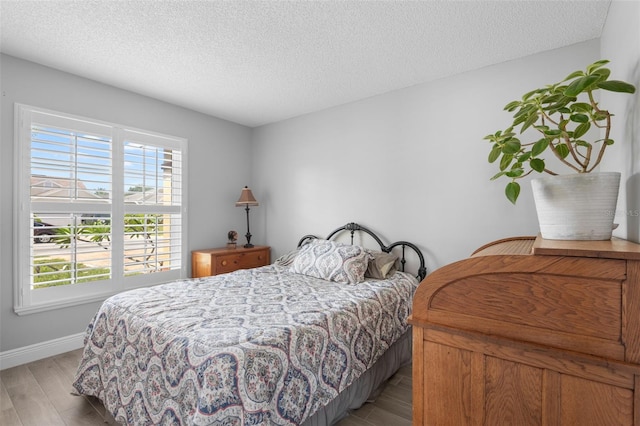 7923 Woburn St, New Port Richey, FL 34653 - bedroom with light wood-style flooring, baseboards, and a textured ceiling