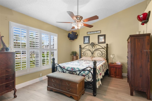 7923 Woburn St, New Port Richey, FL 34653 - bedroom featuring light wood-style floors, a textured ceiling, lofted ceiling, baseboards, and a ceiling fan