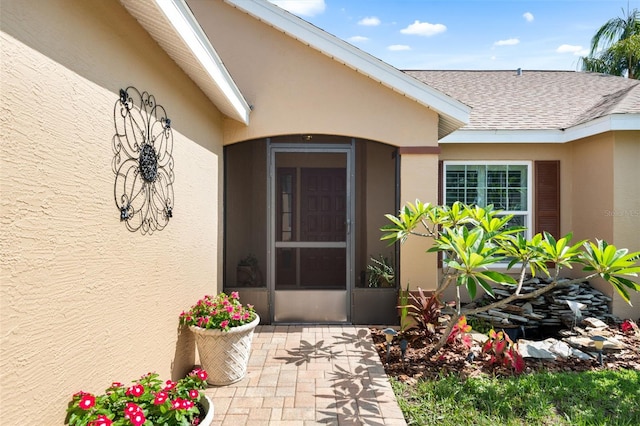7923 Woburn St, New Port Richey, FL 34653 - property entrance with stucco siding, a shingled roof, and a patio