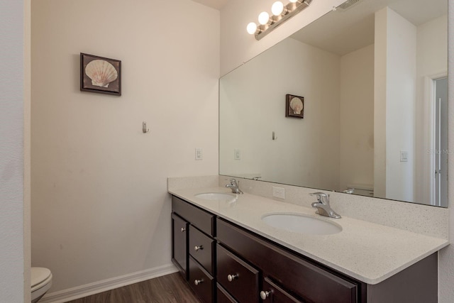 5520 White Marlin Ct, New Port Richey, FL 34652 - bathroom with toilet, double vanity, wood finished floors, and baseboards