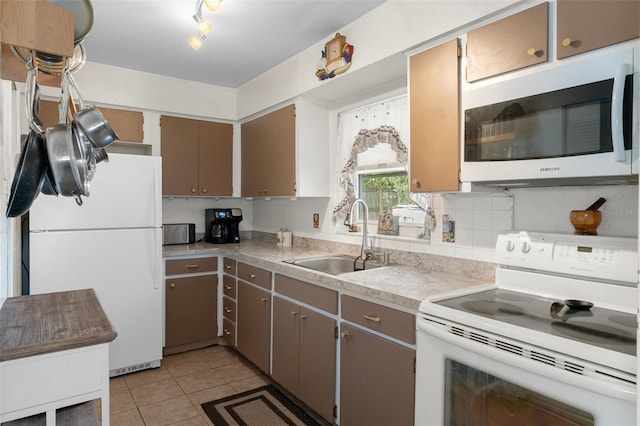 4537 Cynthia Ln, Spring Hill, FL 34606 - kitchen featuring white appliances, a sink, light tile patterned floors, light countertops, and backsplash