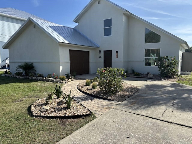 4104 Pine Dale Ct, Hernando Beach, FL 34607 - view of front of house with driveway, stucco siding, an attached garage, a front yard, and metal roof