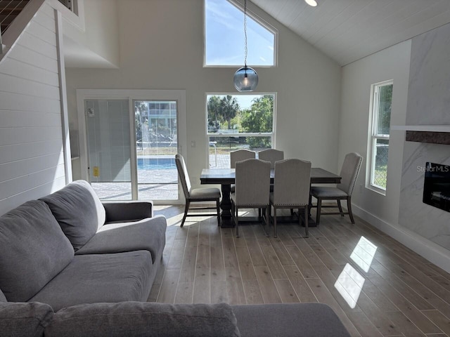 4104 Pine Dale Ct, Hernando Beach, FL 34607 - dining room featuring wood finished floors, baseboards, and high vaulted ceiling