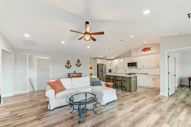 4469 Bahama Dr, Hernando Beach, FL 34607 - living room with vaulted ceiling, light wood-style flooring, ceiling fan, recessed lighting, and baseboards